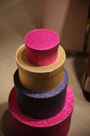 Round sparkling gift boxes standing on top of each other in different sizes and bright colorsの写真素材