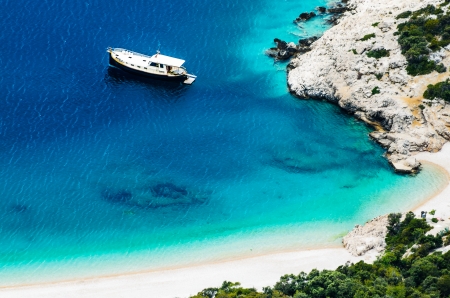 Pebble beach with boat in Cresの写真素材