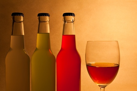 Still-life with three bottles and glass over textured backgroundの写真素材