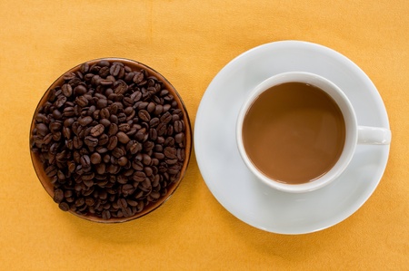 cup of coffee and coffee seed on plate