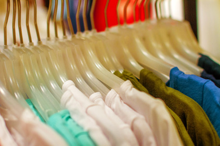 image women's shirts hanging on a hanger in the storecの写真素材