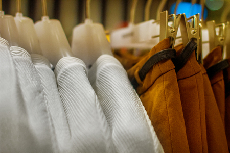 mage blouses and skirts hanging on a hanger in the storecの写真素材