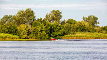 Image of a boat with a motor rushing along the riverの写真素材