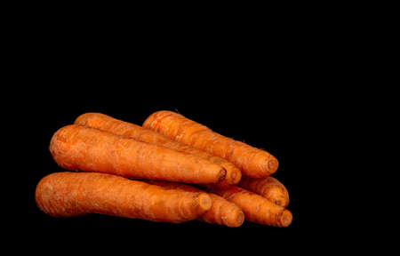 Image of ripe vegetable root vegetable carrot on black background