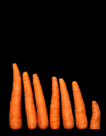 Image of ripe vegetable root vegetable carrot on black background