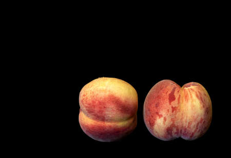 Image of two ripe peaches on black backgroundの写真素材
