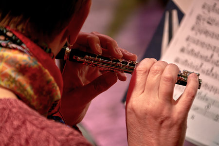 Image of a music girl playing flute by sheet musicの写真素材