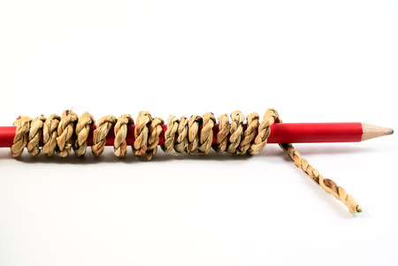 Red pencil tied with rope on white backgroundの写真素材