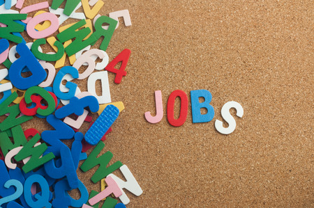 Colourful word jobs with cork board as backgroundの写真素材