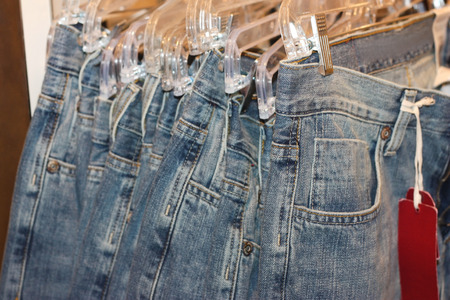 Row of jeans hangind in the storeの写真素材