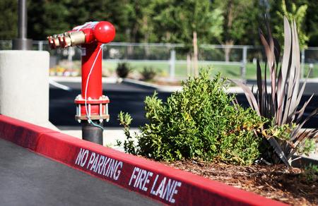 "No Parking Fire Lane" sign on the parking lot, with a fire hydrant on the background.の写真素材