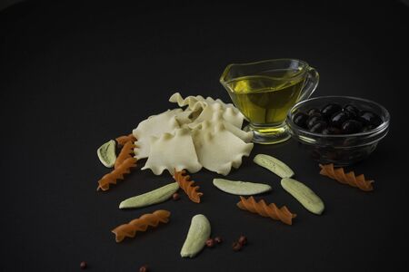 Different spaghetti with olive oil on black background. Top view. Pasta.