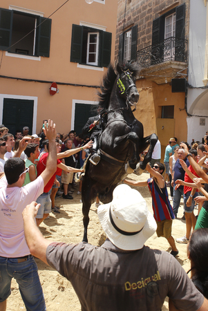 Ciutadella Minorca Spain - June 24, 2015 - A rider rears up on his horse while surrounded by a cheering crowd during the traditional Fiesta of San Joan (Saint John) in downtown Ciutadella, Balearic Island of Menorca, Spain June 24, 2016. The riders of theのeditorial素材