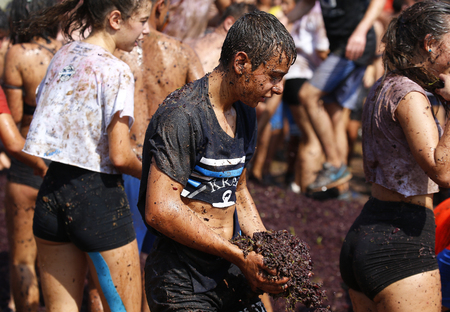 Binissalem Mallorca, Spain - September 11, 2018: People take part in a grapes battle as part of the celebrations of the local harvesting festivities in the village of Binissalem in the Spanish island of Mallorca.のeditorial素材