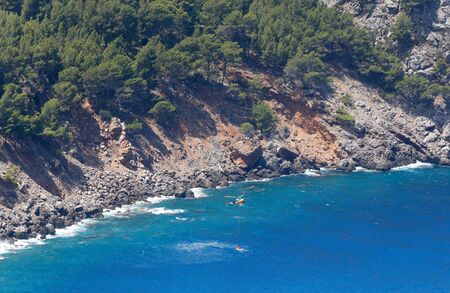 Sa Calobra Mallorca, Spain - July 9, 2019 - Firefighter helicopter seen during his wok to extinguish a fire around the Sa Calobra mountains.のeditorial素材