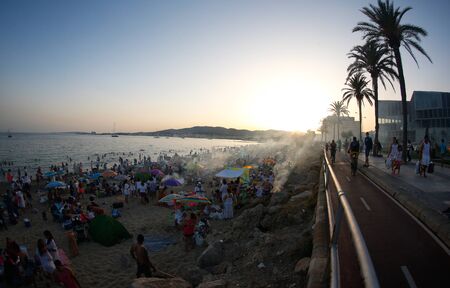 Palma de Mallorca, Spain / June 23, 2019: People meet in the beach near the sea to celebrate the...