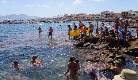 Can Picafort, Mallorca / Spain - August 15, 2019: People enjoy a traditional rubber ducks throw in the water in the beach of can picafort in the island of Mallorca, until two decades ago, live animals were used during this many decades tradition.のeditorial素材