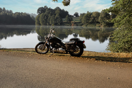 Motorcycle on the road near the lake in the park in autumnの写真素材