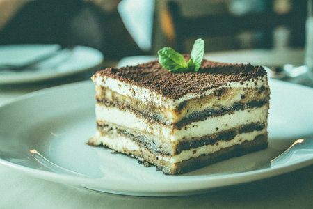Tiramisu cake on white plate in cafe - Vintage filterの写真素材