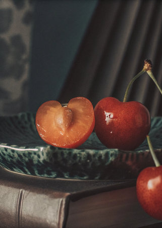 Ripe cherries on a plate with a book on the background