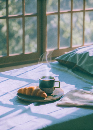 Coffee cup and croissant on the bed in the morningの写真素材