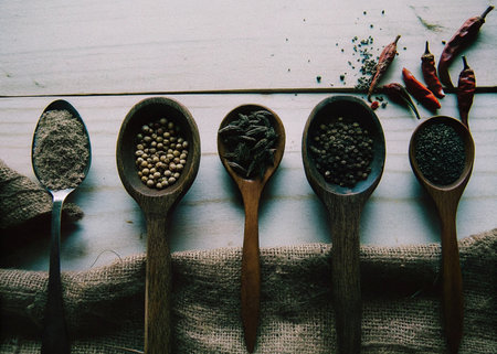 Spices in wooden spoons on a wooden background. Vintage style.の写真素材