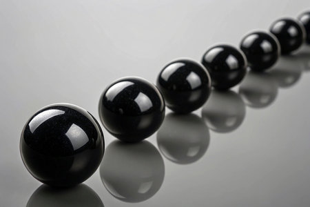 Black balls in a row on a gray background, close-upの素材