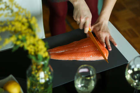 Cutting raw salmon for homemade sushiの写真素材