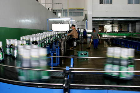 Workers at Tsingtao Brewery in Xuanhua work on the production line.のeditorial素材