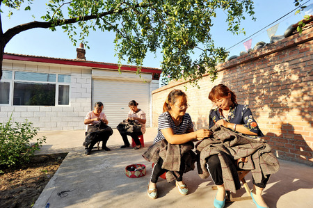 hebei Poverty alleviation programme, women doing sewing workのeditorial素材