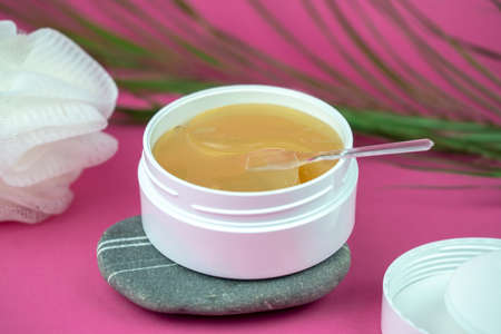 golden under eyes patches in a white container, anti aging skin care, female body care background, pink backdropの写真素材