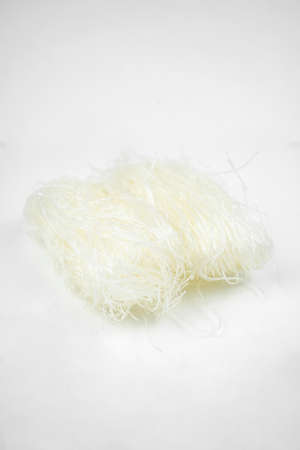 uncooked dry glass noodle, white bean asian vermicelli, rice noodles, isolated on whiteの写真素材