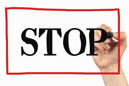 Stop sign with red frame. Doodle  on a whiteboard, written with black and red marker in a hand. Scribble sketch text on a boardの写真素材