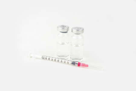 Two vials with medicine and syringe for injection treatment. Covid-19 vaccine concept. Isolated on...