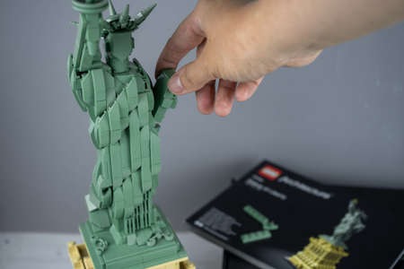Lego Liberty Statue, mini copy of liberty statue in lego architecture addition. Adult person gathers...