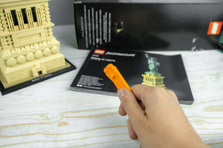 Lego Liberty Statue, mini copy of liberty statue in lego architecture addition. Adult person gathers...