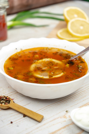 Traditional russian soup solyanka. Hodgepodge soup with meat, lemon and olives. Served with sour creamの写真素材