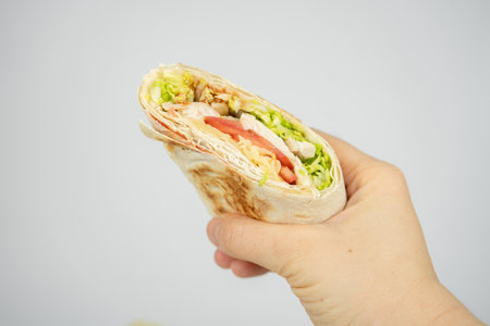 Homemade shawarma / burrito / pita / chicken roll with vegetables and sauce.の写真素材