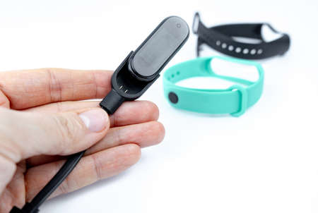 smart fitness bracelet with colored strap with charger isolated white background