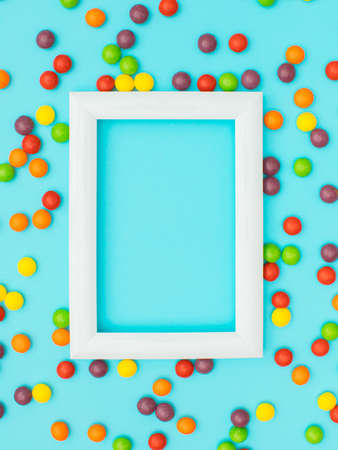 Small colorful balls around the frame on blue background. Love background flat lay concept.の写真素材