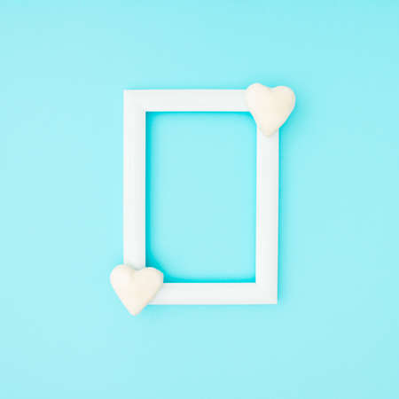 Love background minimal concept. Small white hearts on corners of frame on blue background.
