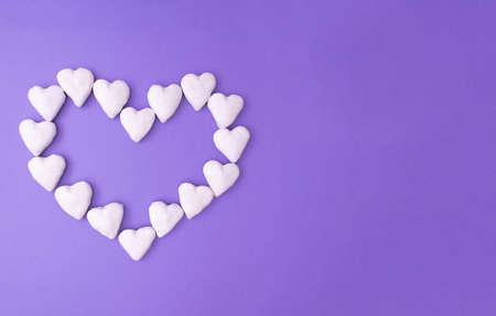 Love concept idea with big heart made from small white hearts on a purple background with copy space. Creative flat lay.の写真素材