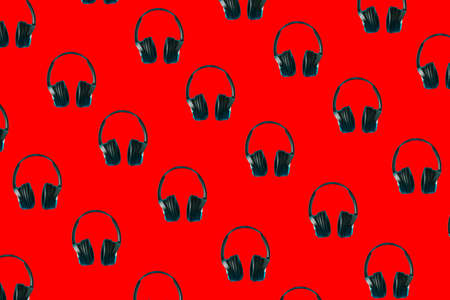 A pattern of black headphones on a red background. Music Abstract 3D Minimal Background Art.