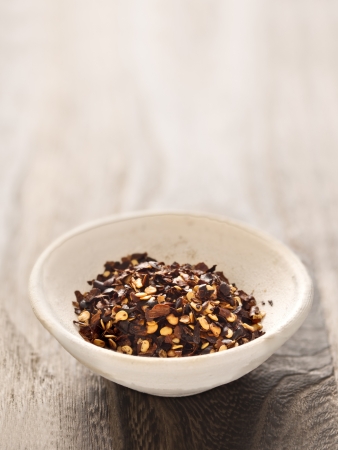 close up of a bowl of dried red chili flakesの写真素材