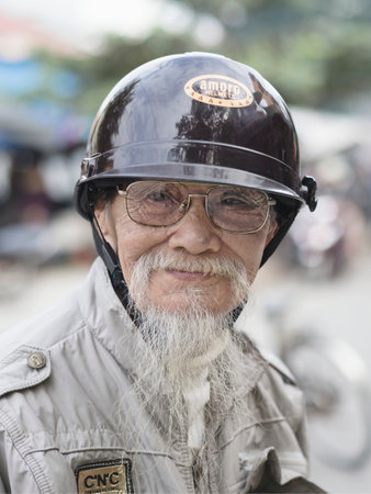 Hoi An, Vietnam - Dec 28, 2016: Portrait of an old biker in Hoi An who keeps his goatee like his...