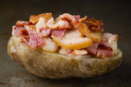 close up of rustic baked jacket potato with baconの写真素材