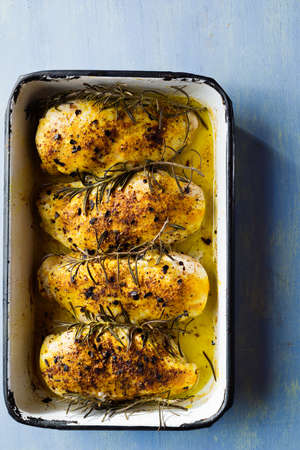 close up of tray of golden roast baked chicken breastの写真素材