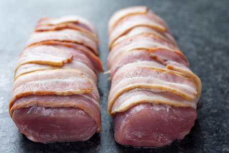 close up of bacon  wrapped pork tenderloin  raw uncookedの写真素材