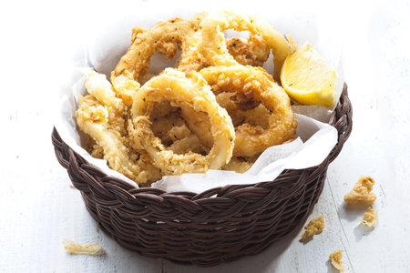 close up of basket of golden italian fried calamariの写真素材