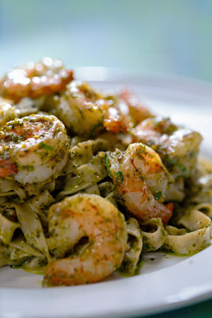 close up of a plate of seafood pasta in pesto sauceの写真素材
